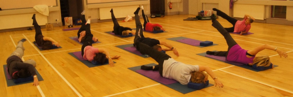 Pilates class conducting mat exercises
