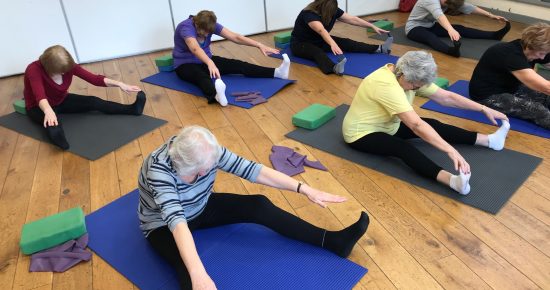 Picture of Pilates class conducting sitting stretch exercises